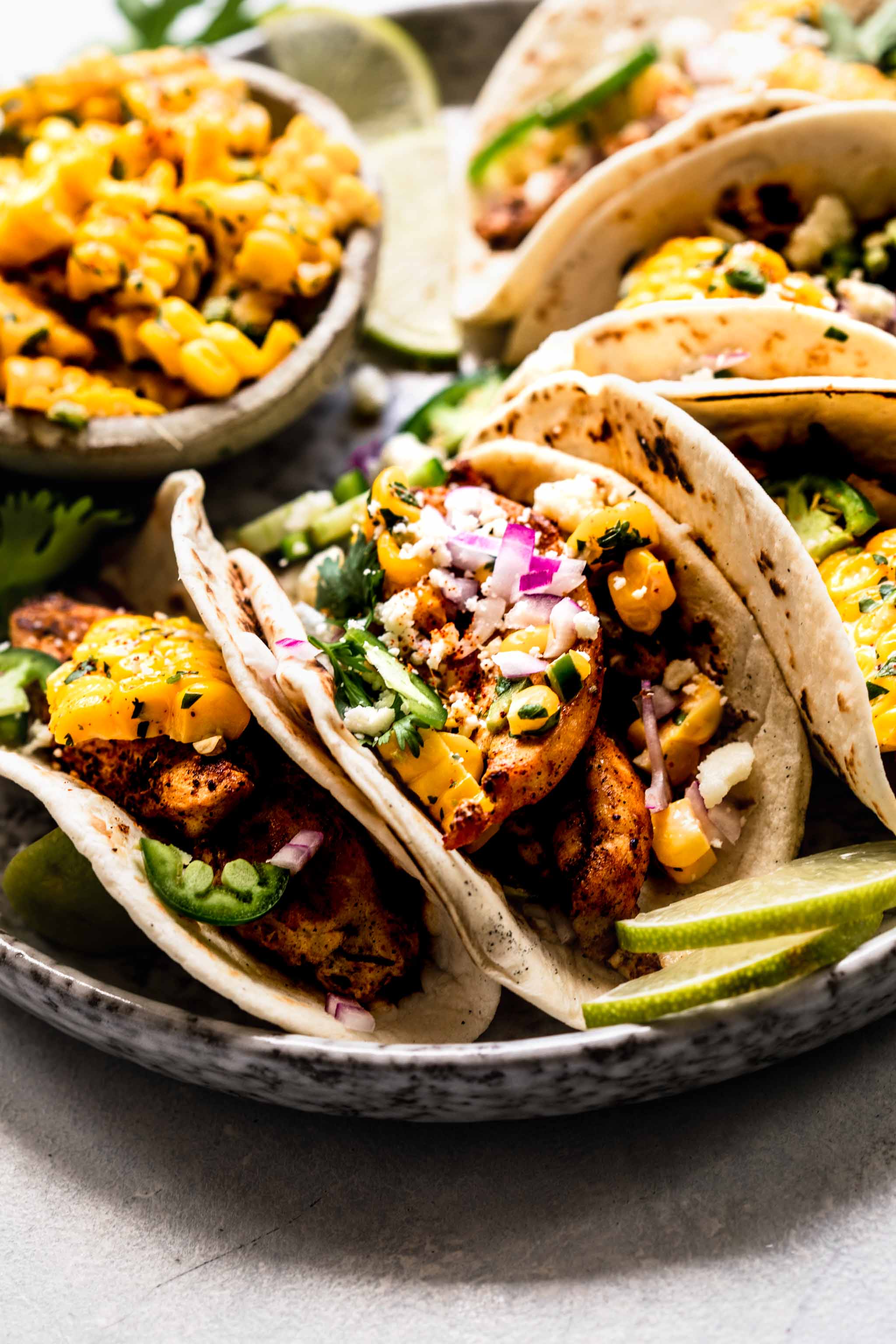 Side view of street corn tacos arranged on plate. 