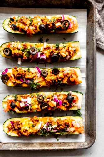 Zucchini taco boats on baking tray after cooking.