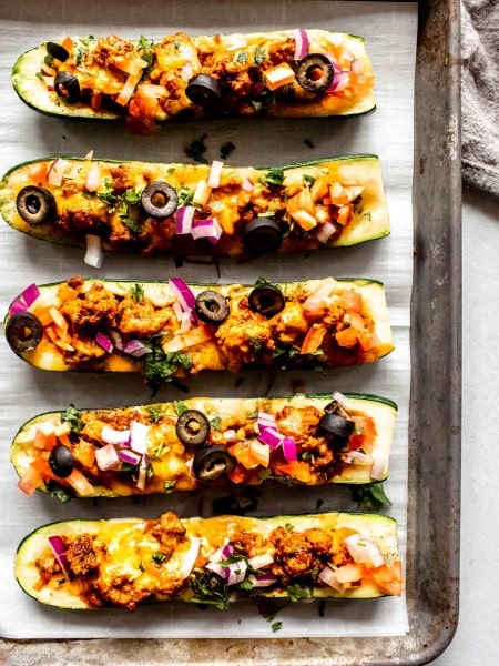 Zucchini taco boats on baking tray after cooking.