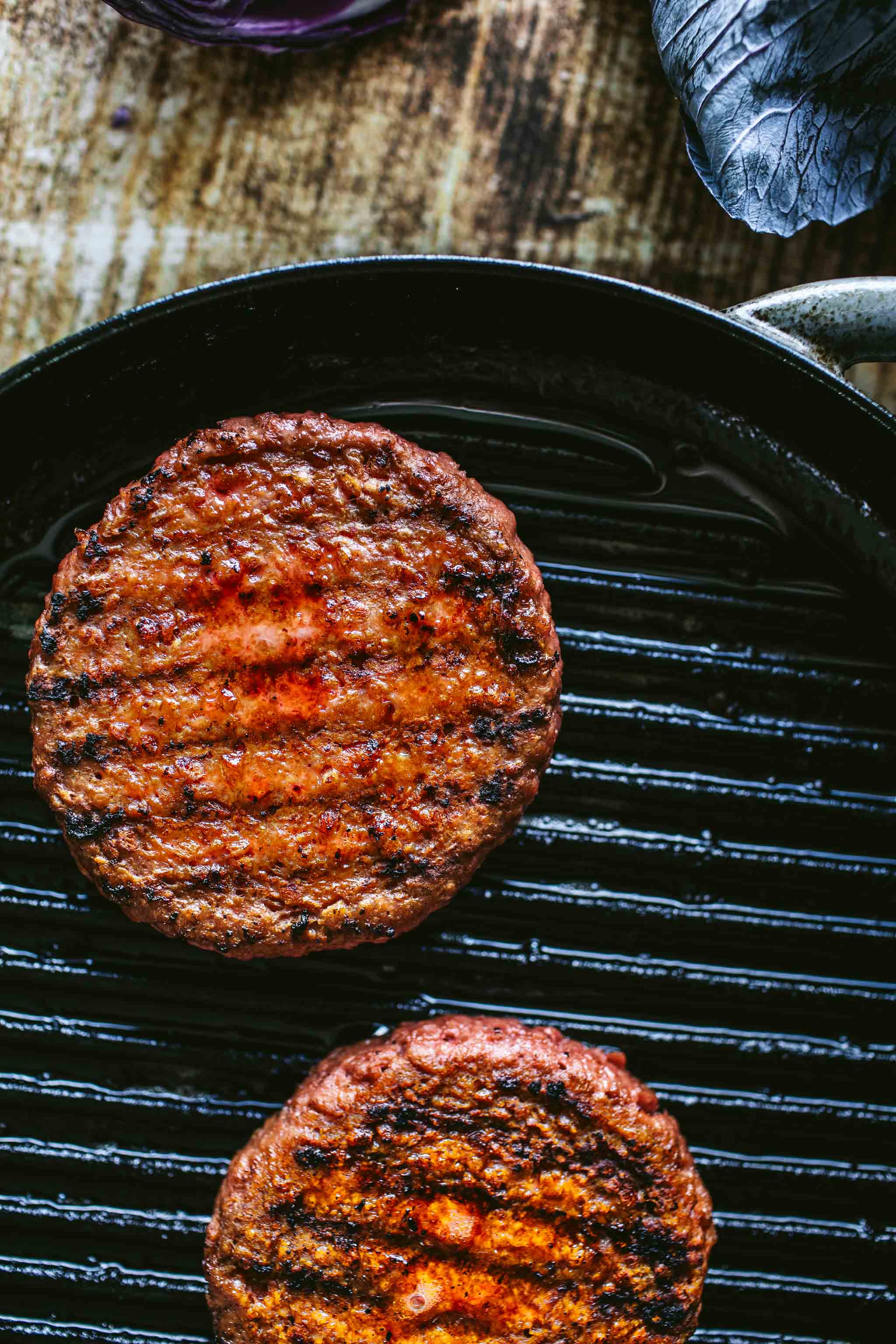 Veggie burgers cooking on grill.