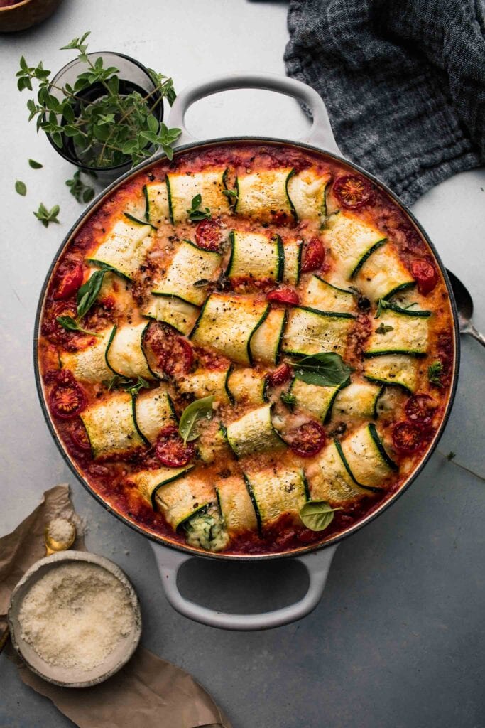 Overhead shot of zucchini lasagna rolls in skillet.