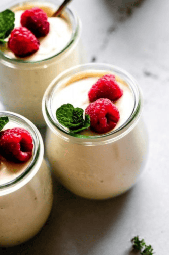 SIDE VIEW OF THREE JARS OF RASPBERRY RICOTTA MOUSSE.