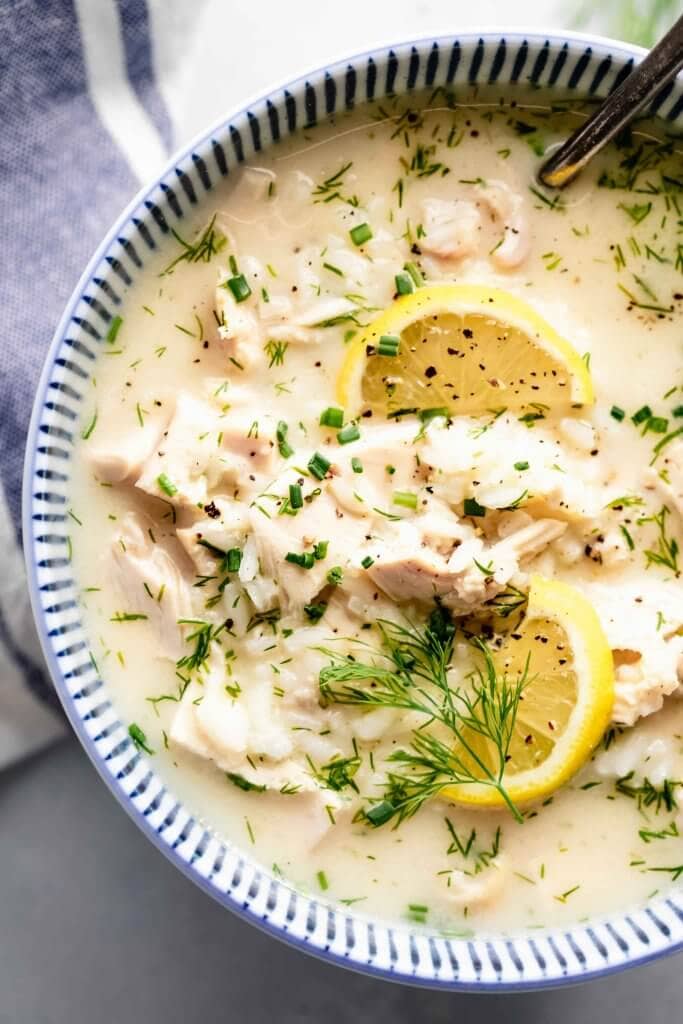 Bowl of avgolemono soup topped with lemons. 