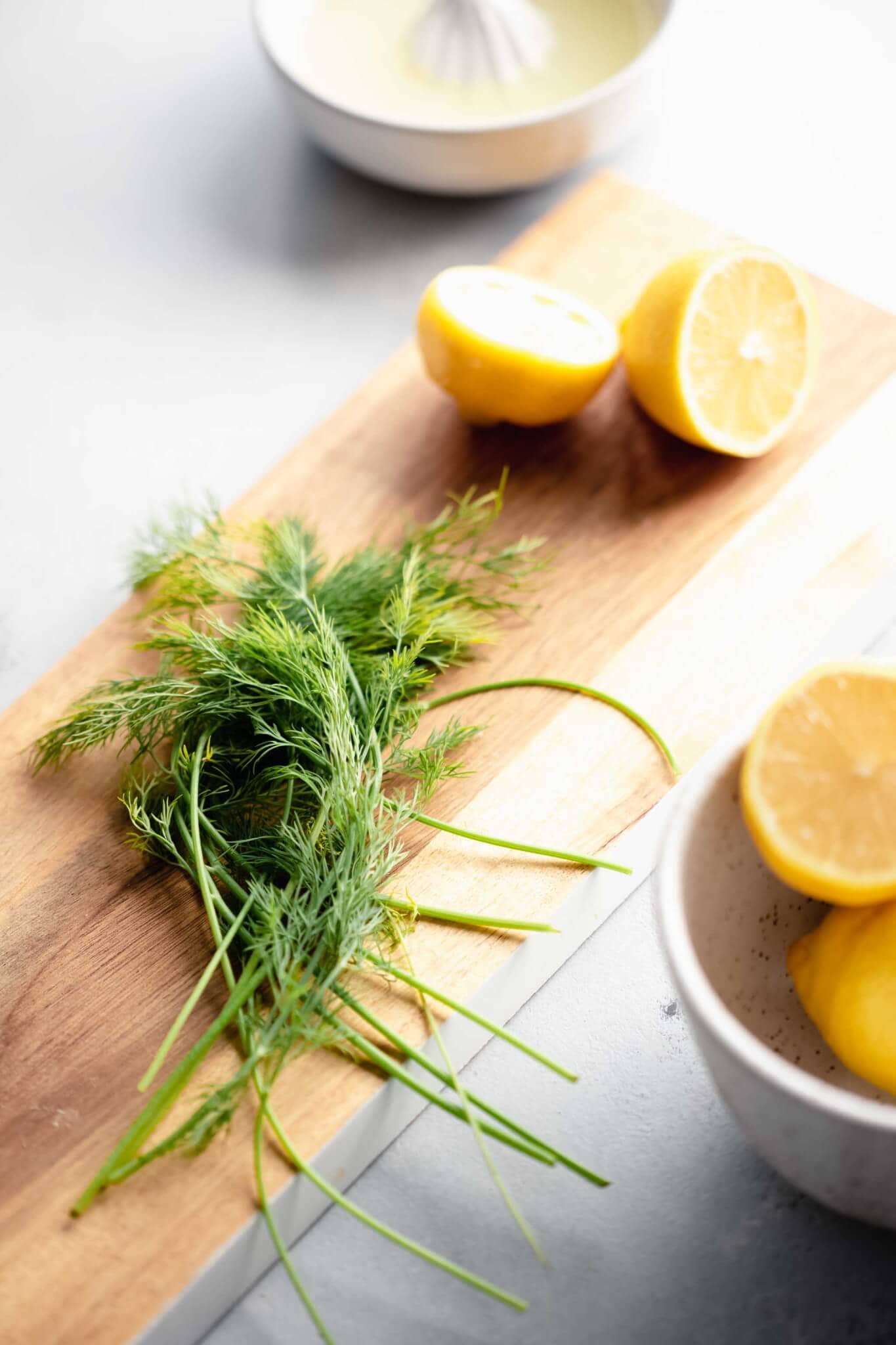 Dill and lemons on cutting board. 