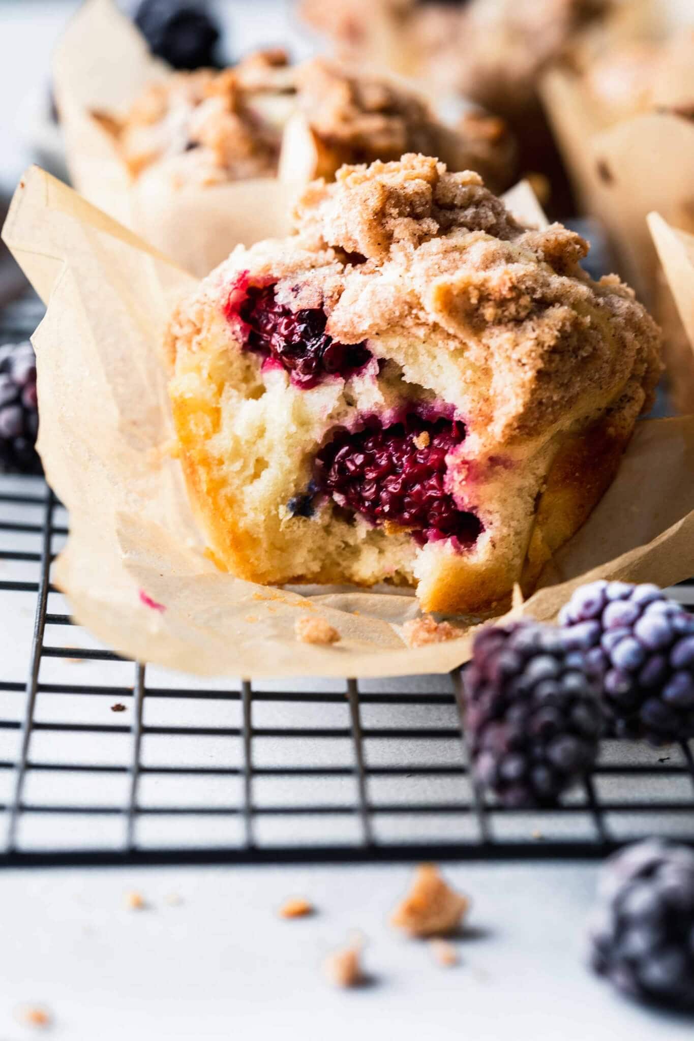 Side view of blackberry muffin with bite taken out of it.