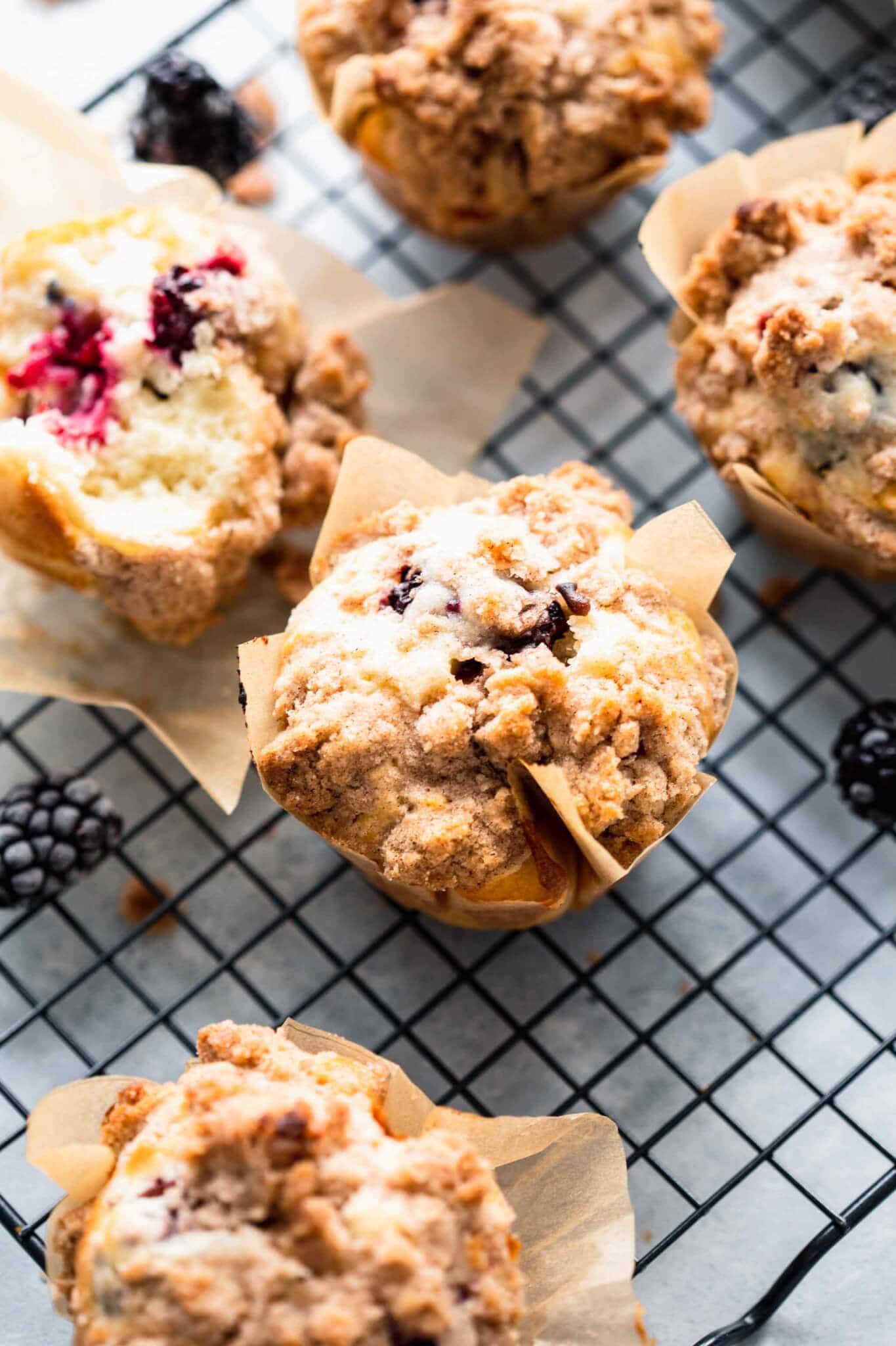 Side view of blackberry muffins on cooling rack.