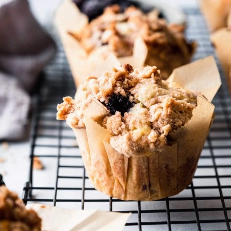 Side view of blackberry muffin in parchment paper liner.