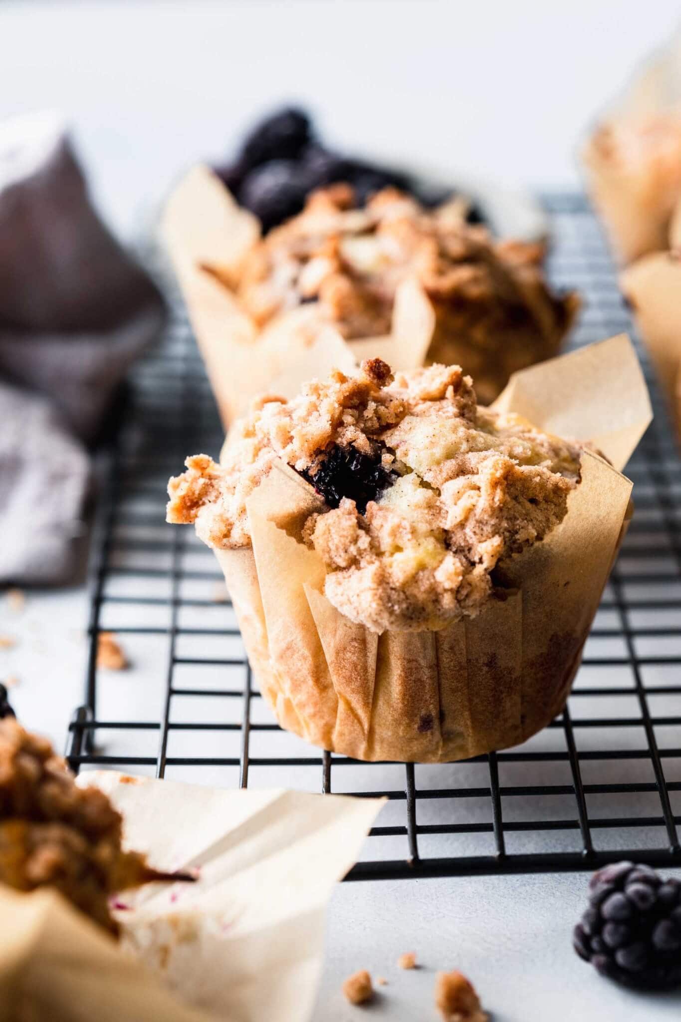 Side view of blackberry muffin in parchment paper liner.