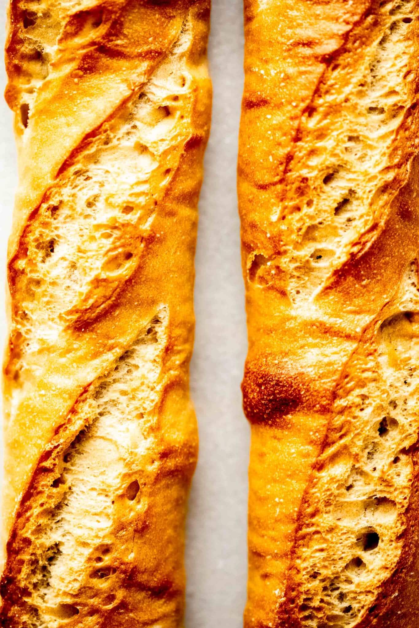 Two baguette loaves on white background. 