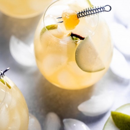 Ginger pear cocktails on counter with ice.