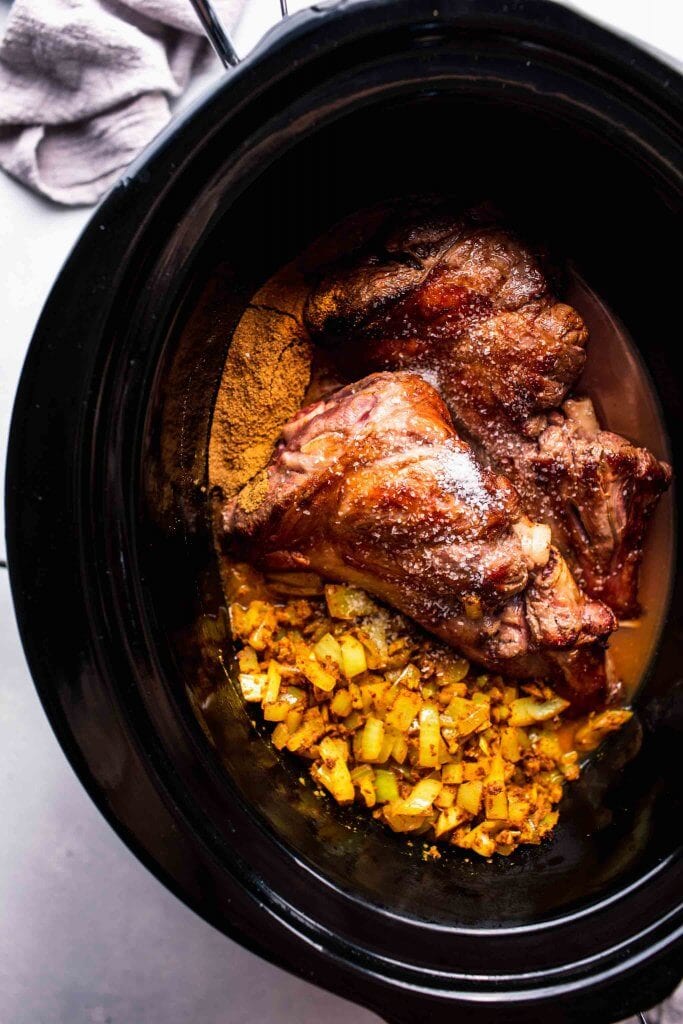 Legs of lamb in slow cooker before cooking.