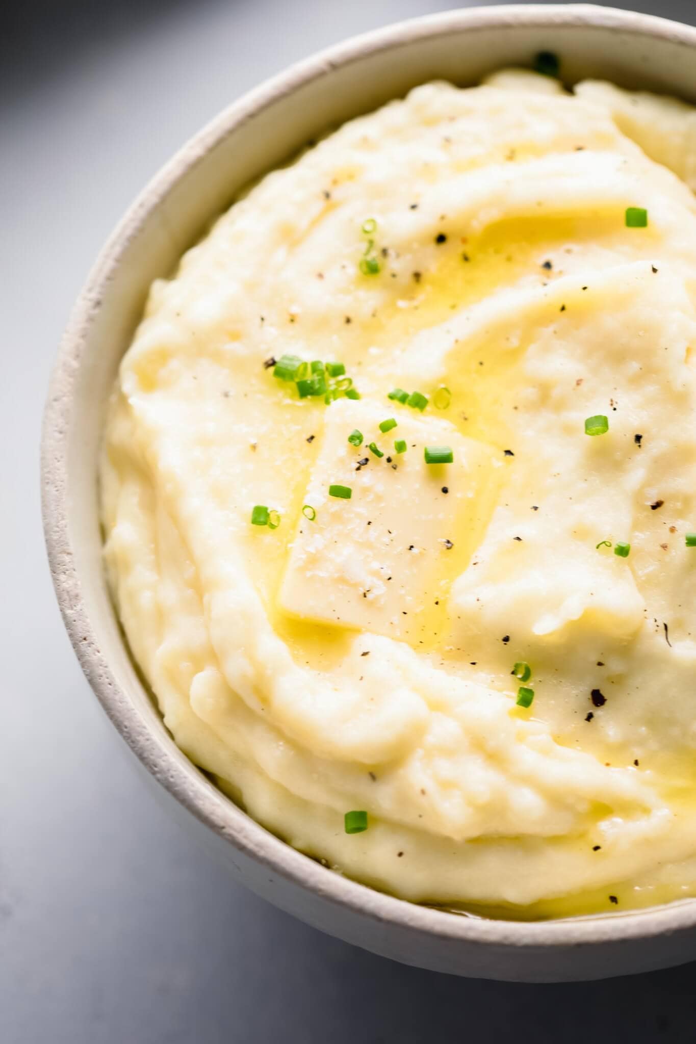 Overhead shot of bowl of mashed potatoes topped with a pat of butter.