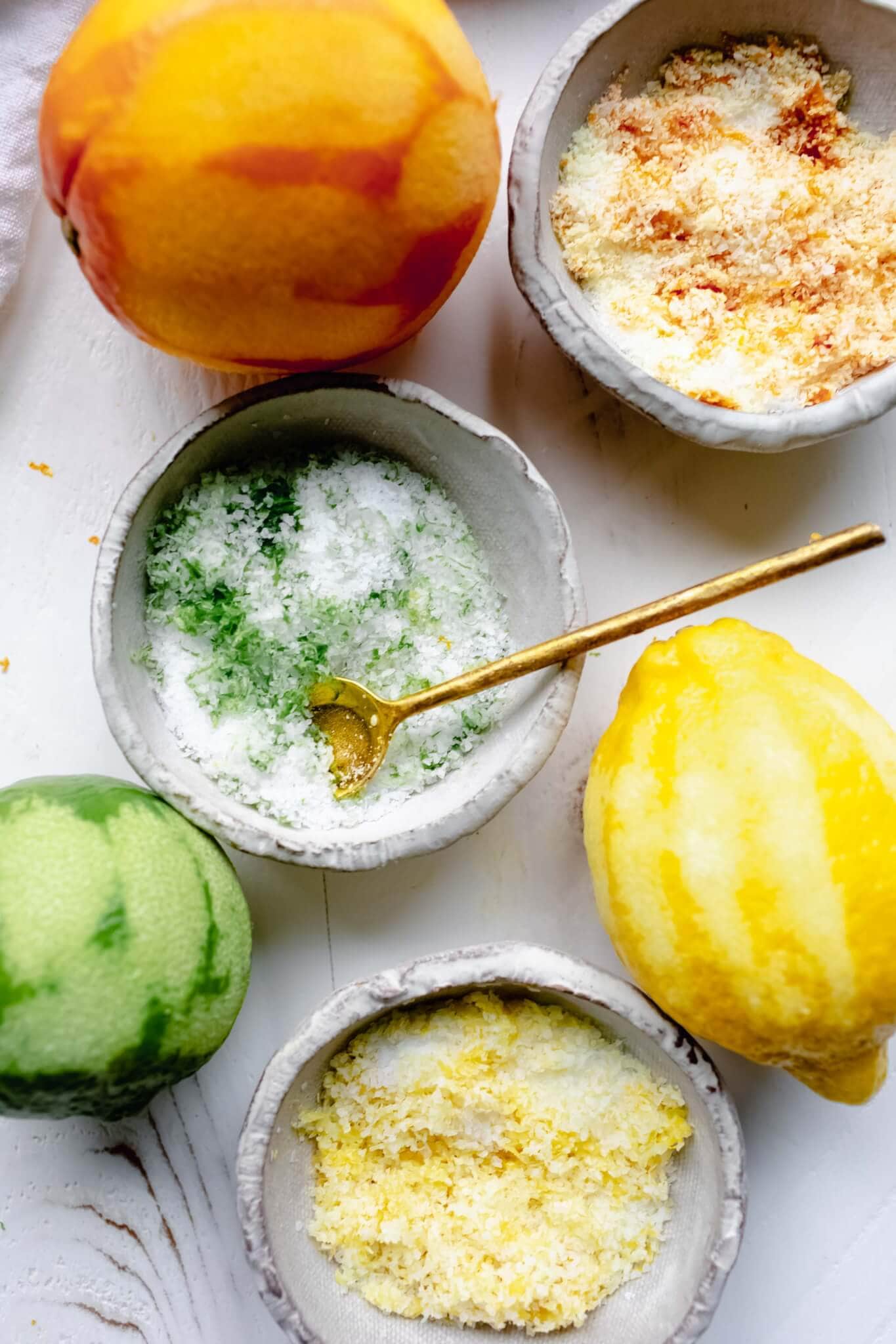 Overhead shot of three types of citrus salt - orange, lime and lemon