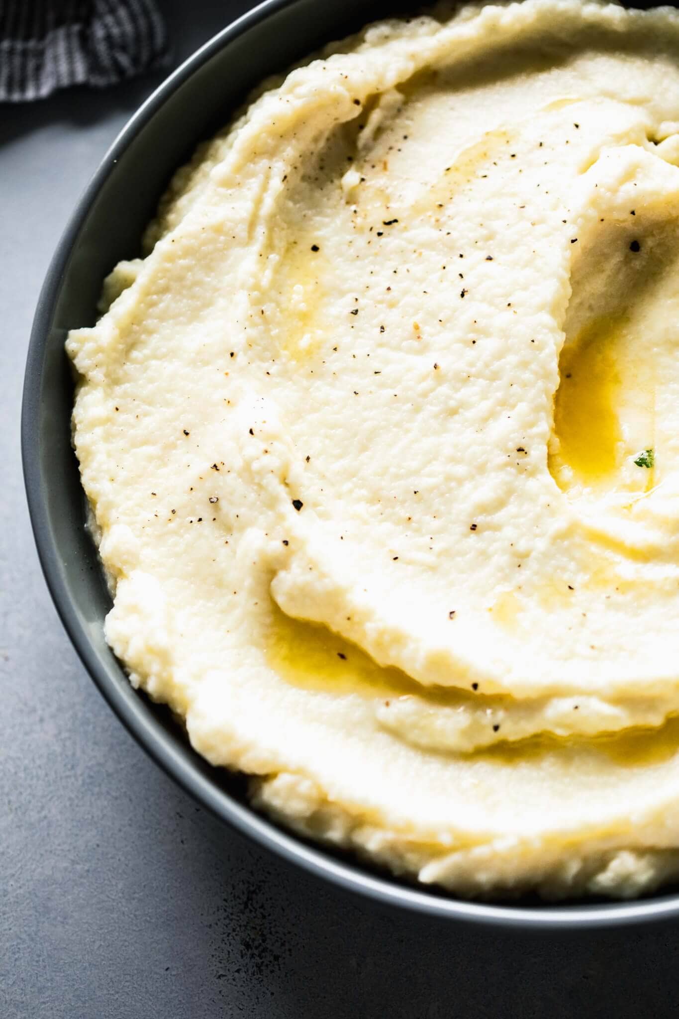 Close up side view of bowl of mashed cauliflower. 