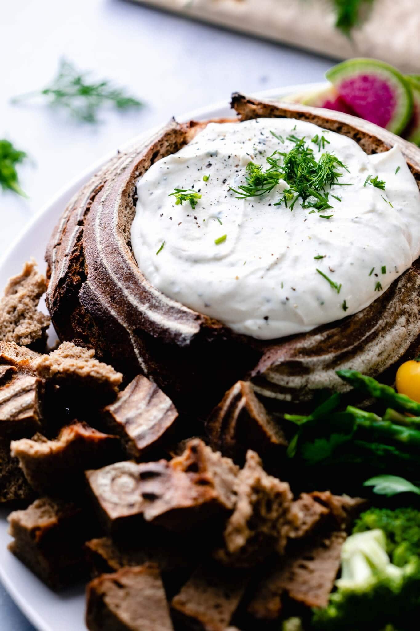 Side view of greek yogurt dip in bread bowl.