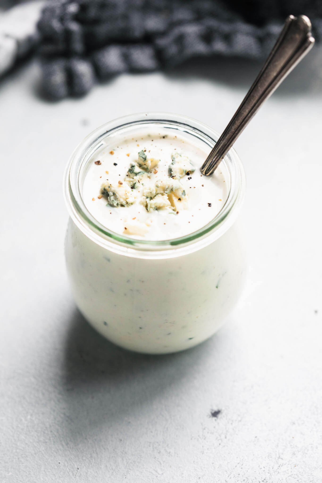 Side view of container of blue cheese dressing in small jar.