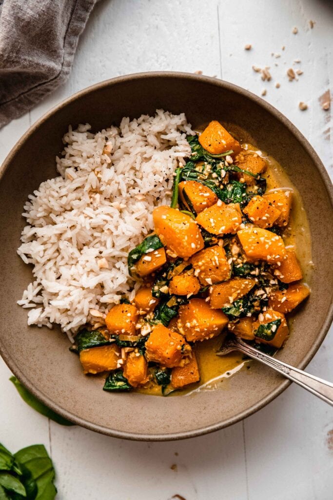 Bowl of butternut curry with rice and spoon.