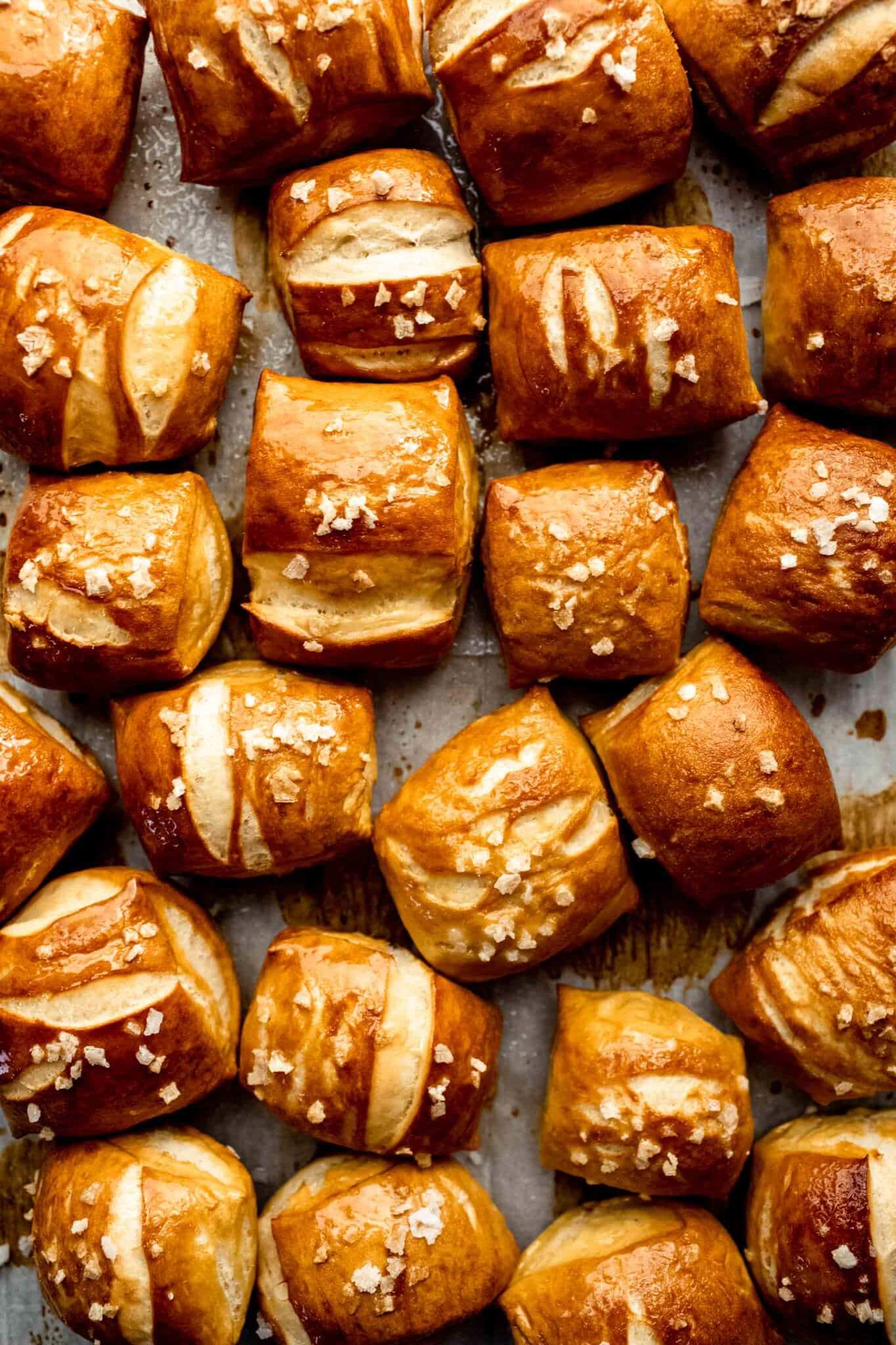 Close up of pretzel bites on baking sheet sprinkled with coarse salt.