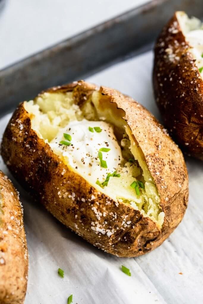 Air fryer baked potato topped with sour cream. 