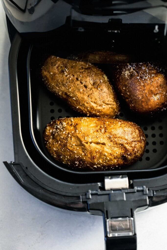 Cooked potatoes in air fryer basket. 