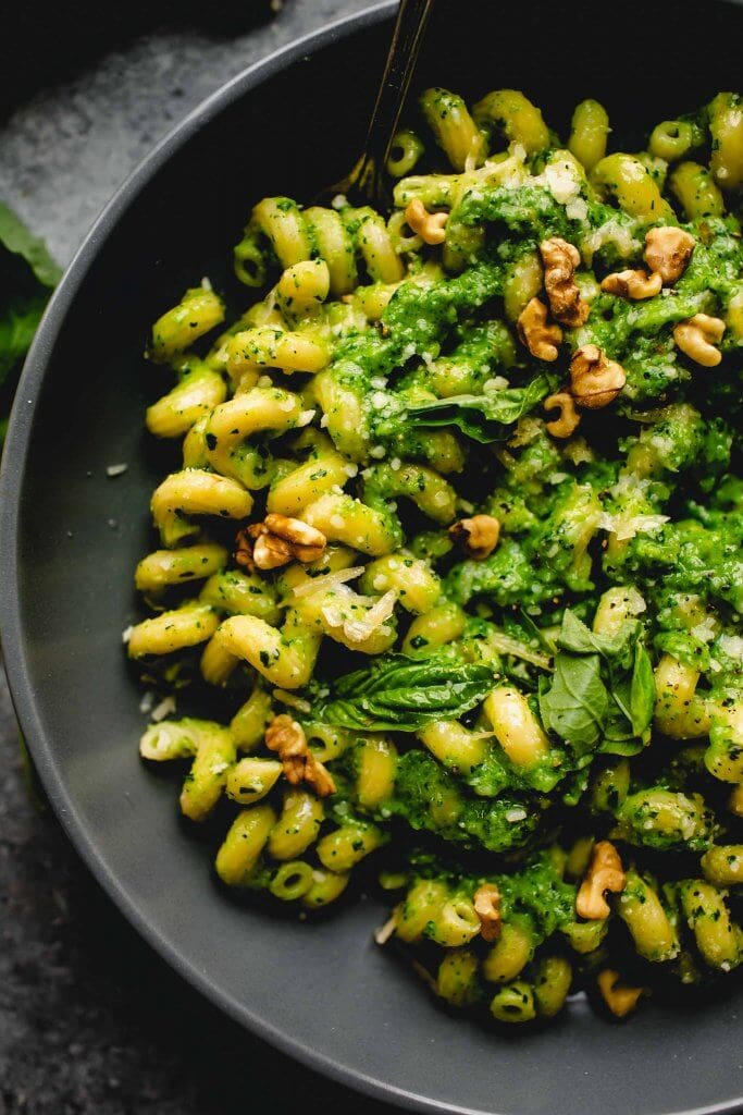 Overhead close up of bowl of pasta tossed with broccoli pesto.