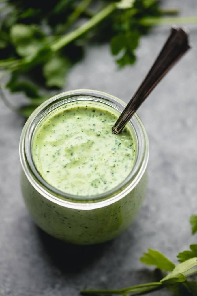Small jar of green goddess dressing with spoon