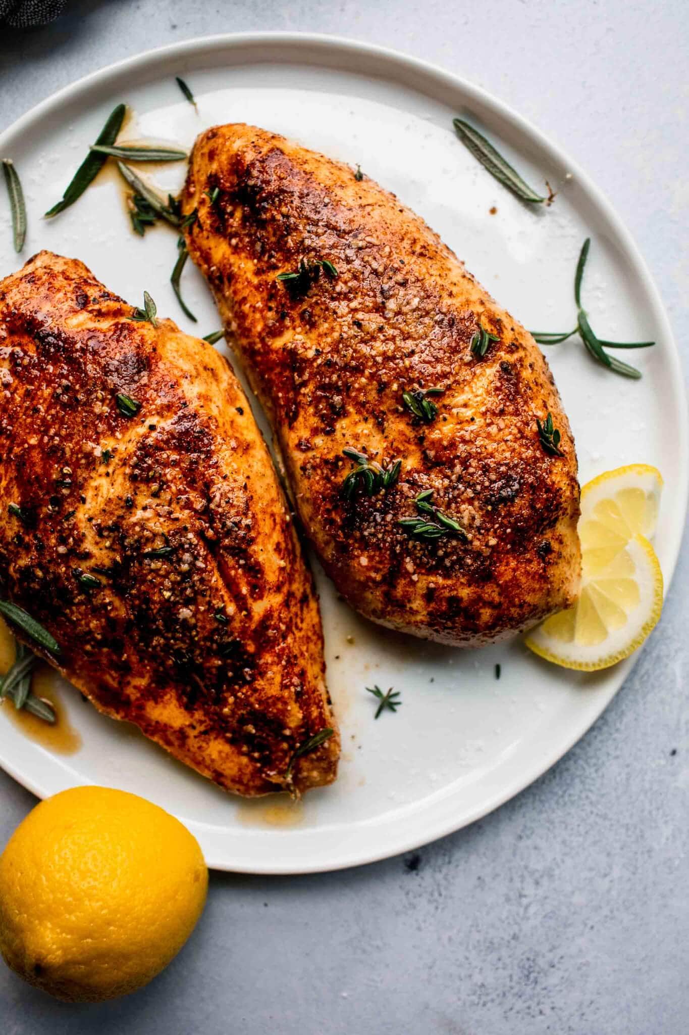 Two whole chicken breasts cooked sous vide after browning in skillet.