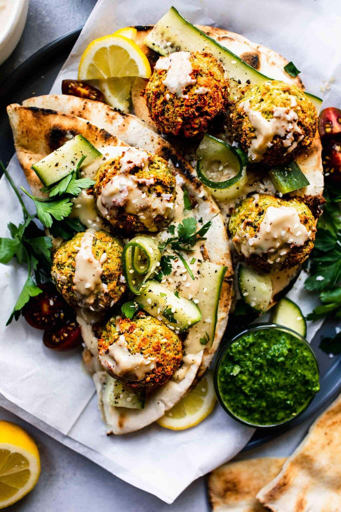 Falafel balls stuffed into pita with ribbons of cucumber, hummus and green sauce.