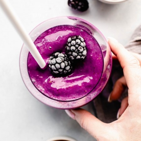 Hand holding blackberry smoothie