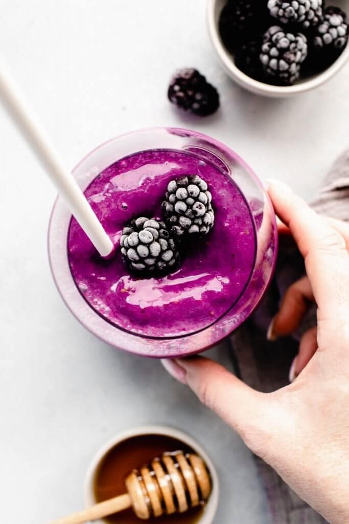 Hand holding blackberry smoothie