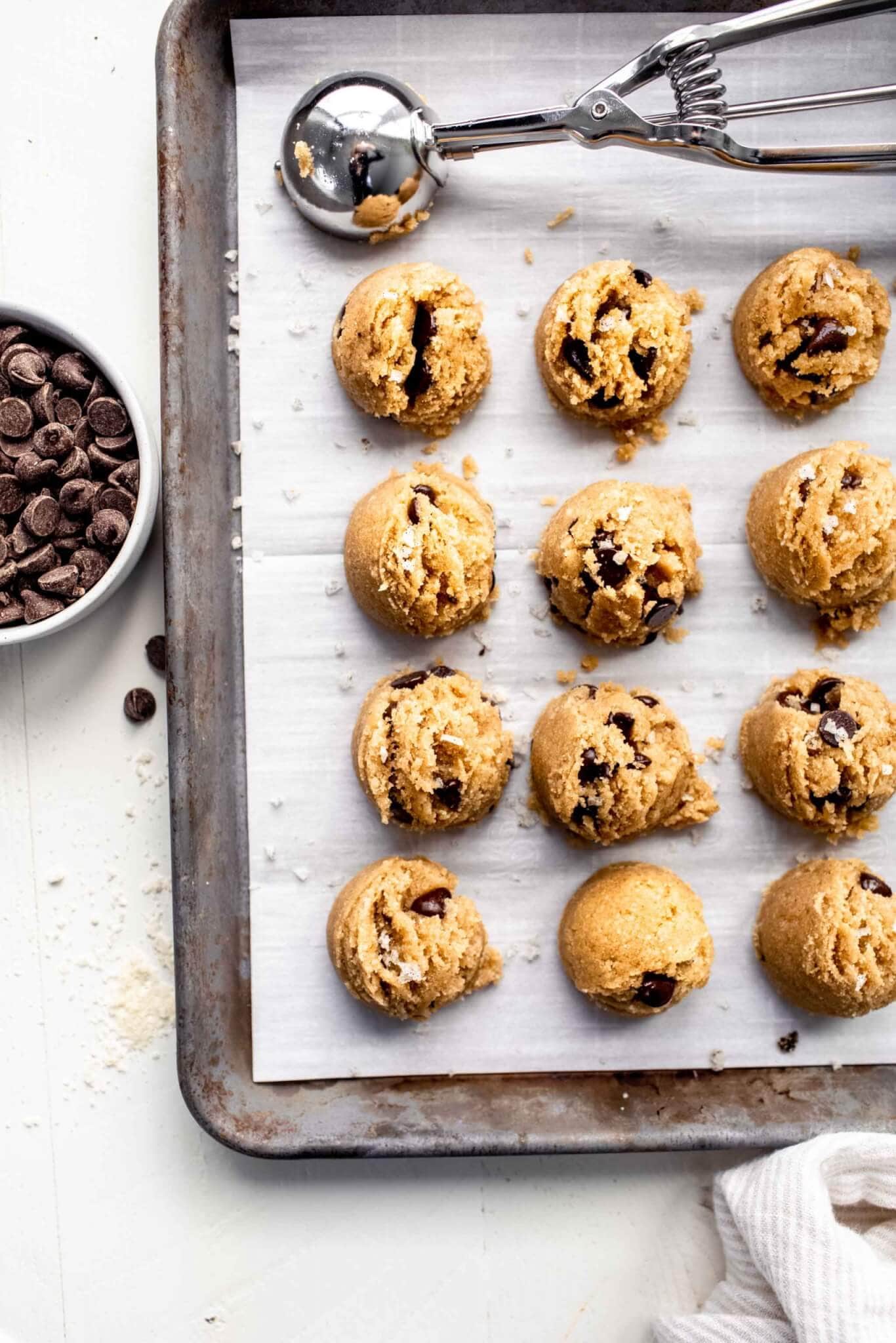 Cookie dough bites scooped out on parchment paper lined baking sheet