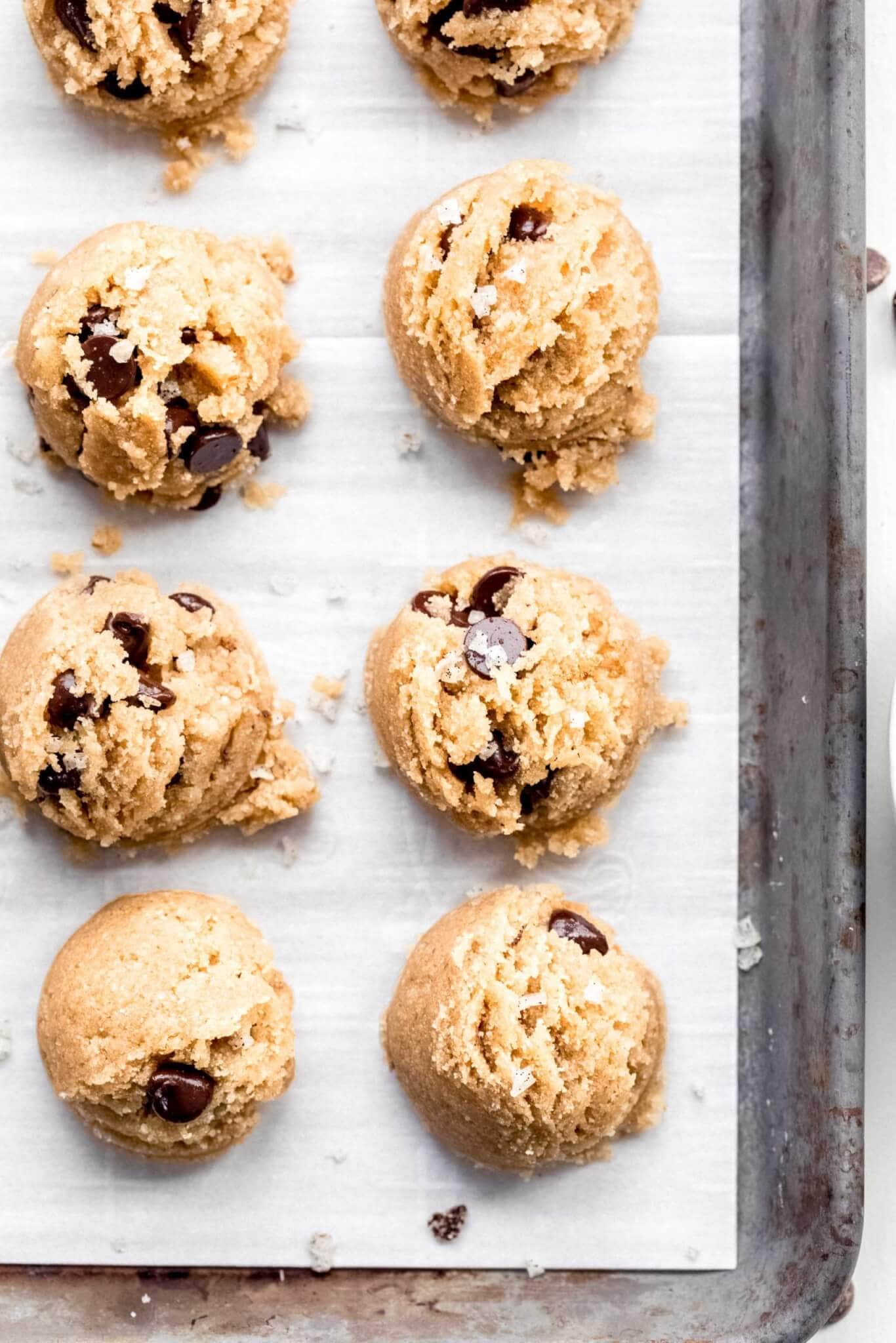 Cookie dough bites scooped out on parchment lined baking sheet.