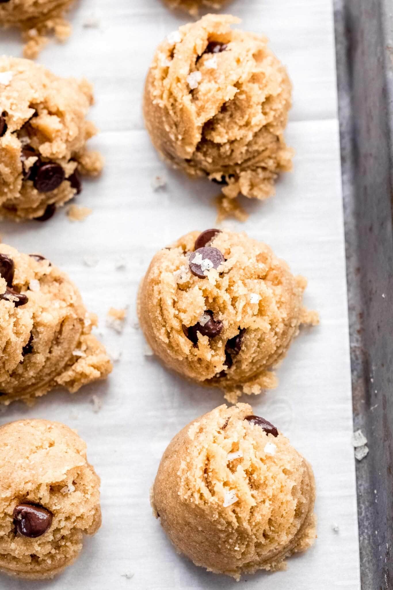 Cookie dough bites scooped out on parchment paper lined baking sheet