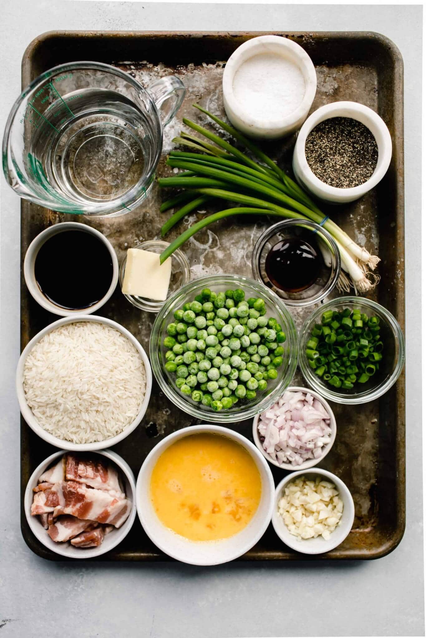 Ingredients needed for fried rice laid out on baking sheet. 