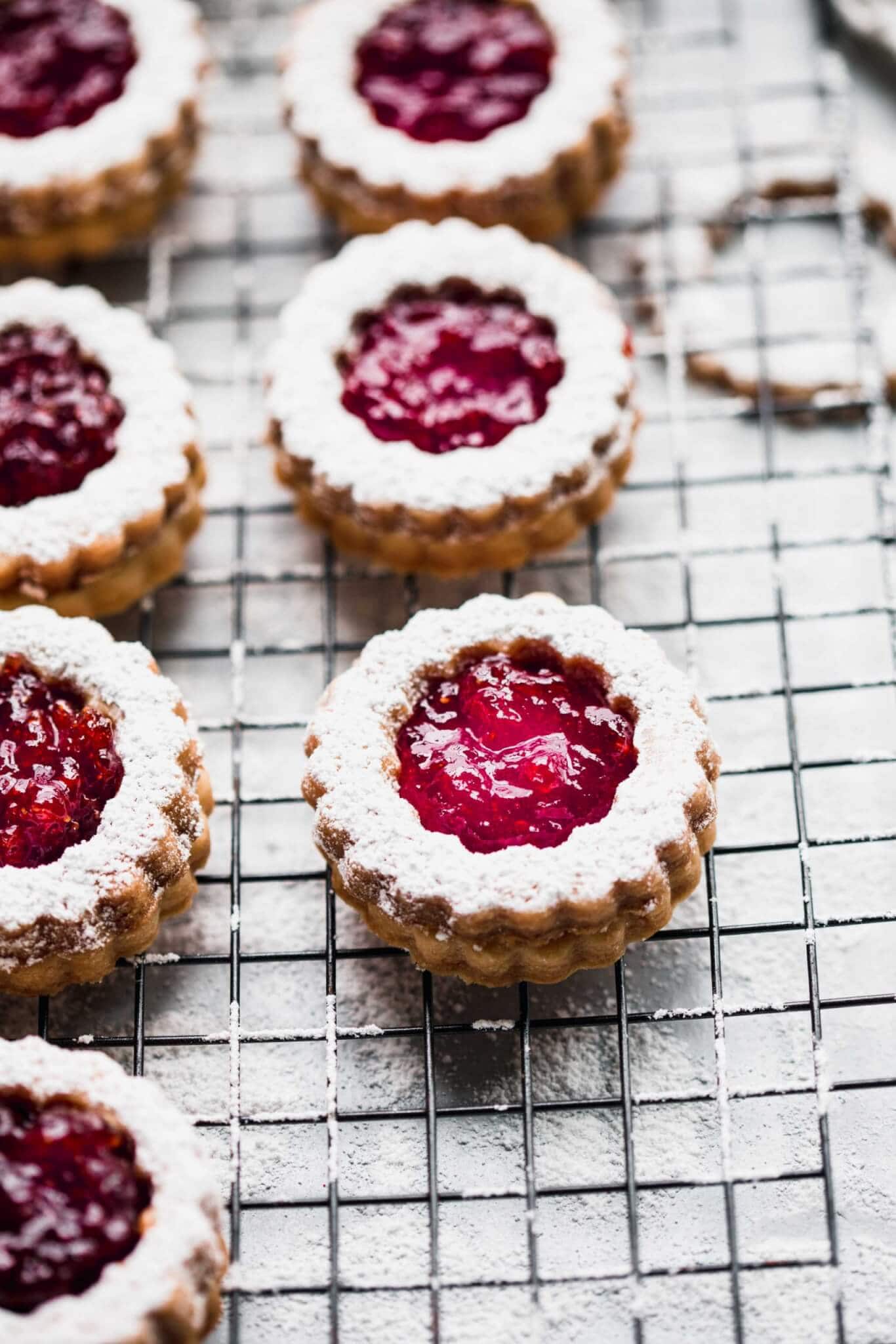 Baked and assembled linzer cookies on cooling rack.