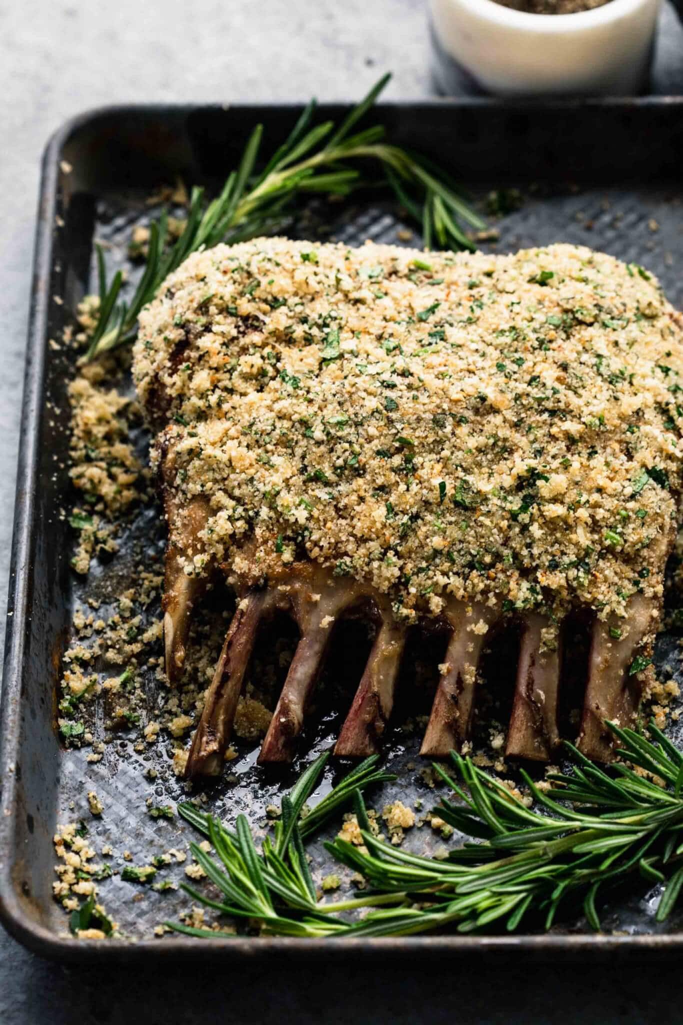 Rack of lamb coated with breadcrumbs before baking in oven.