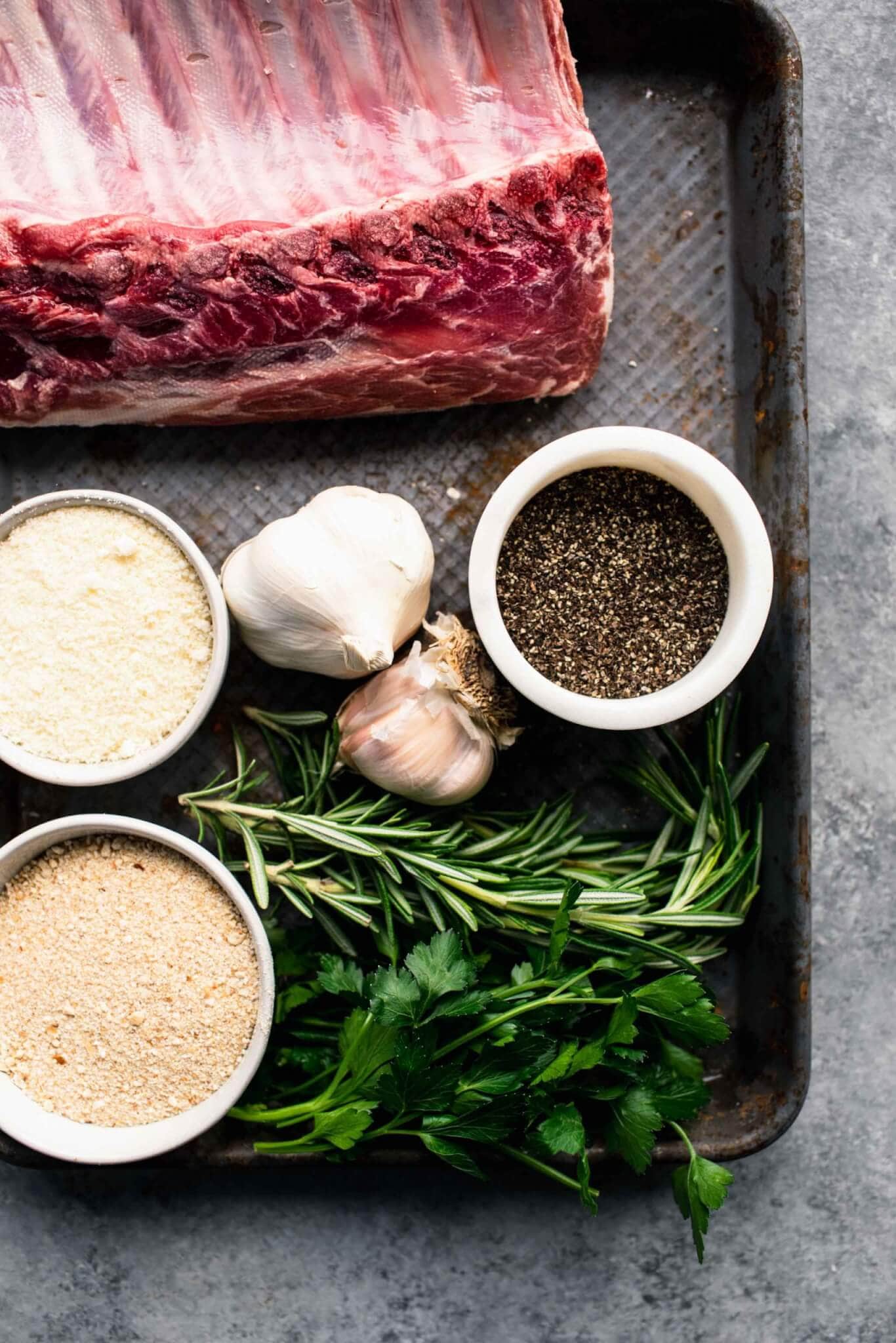 Ingredients for herb crusted rack of lamb laid out on baking sheet.