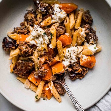 Close up of bowl of butternut pasta with fork.