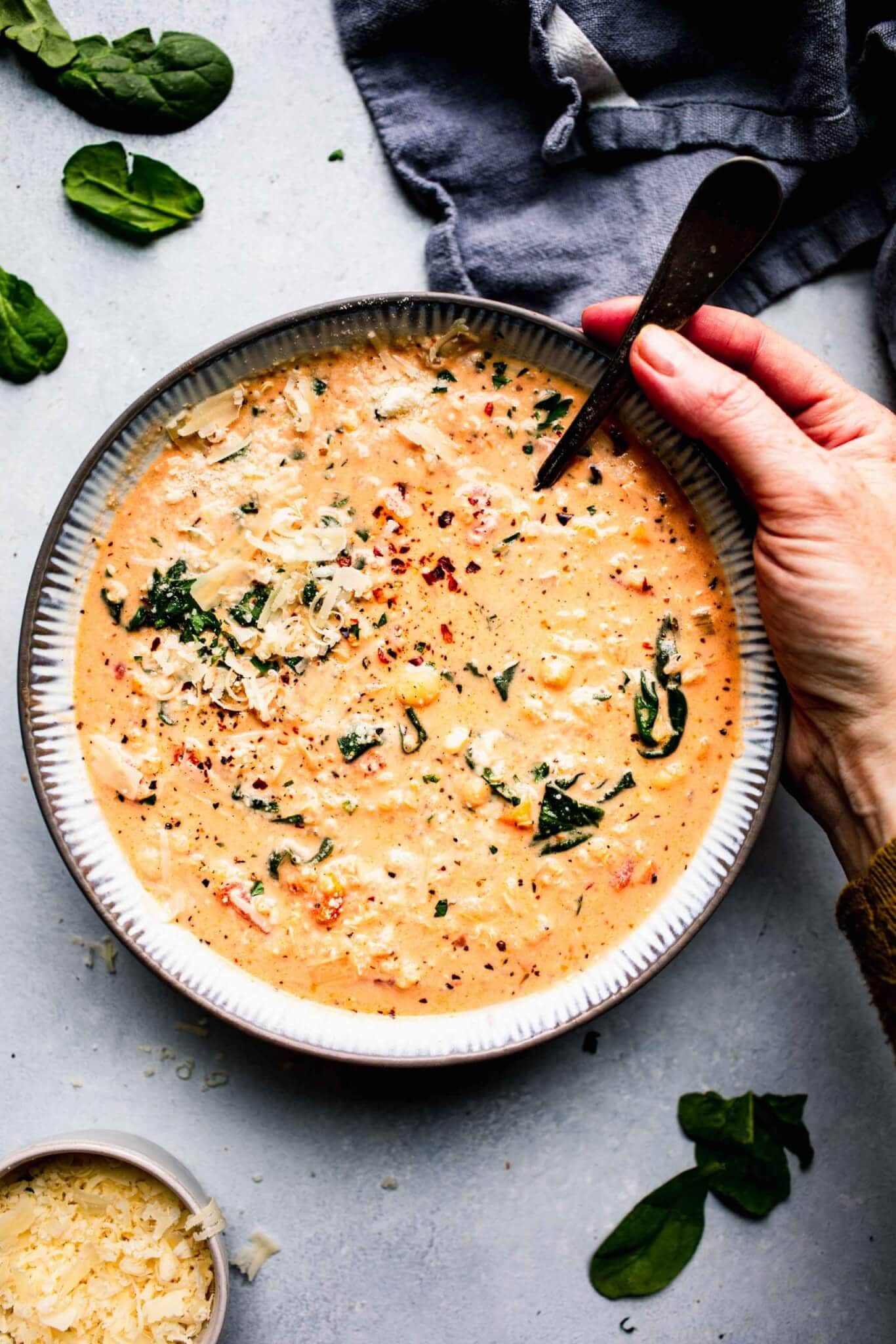 Bowl of creamy quinoa soup with spoon. 