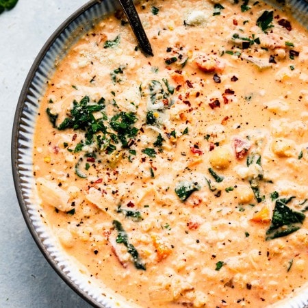 Bowl of creamy quinoa soup with spoon.