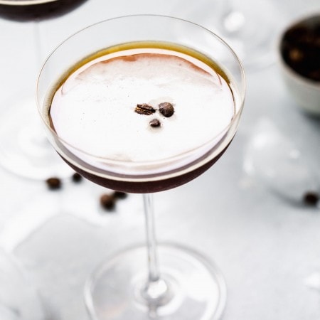 Overhead close up of prepared espresso martini topped with three coffee beans.