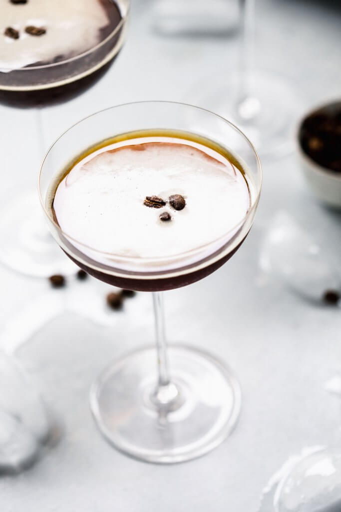 Overhead close up of prepared espresso martini topped with three coffee beans.