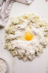Mound of potatoes and flour with egg in center.