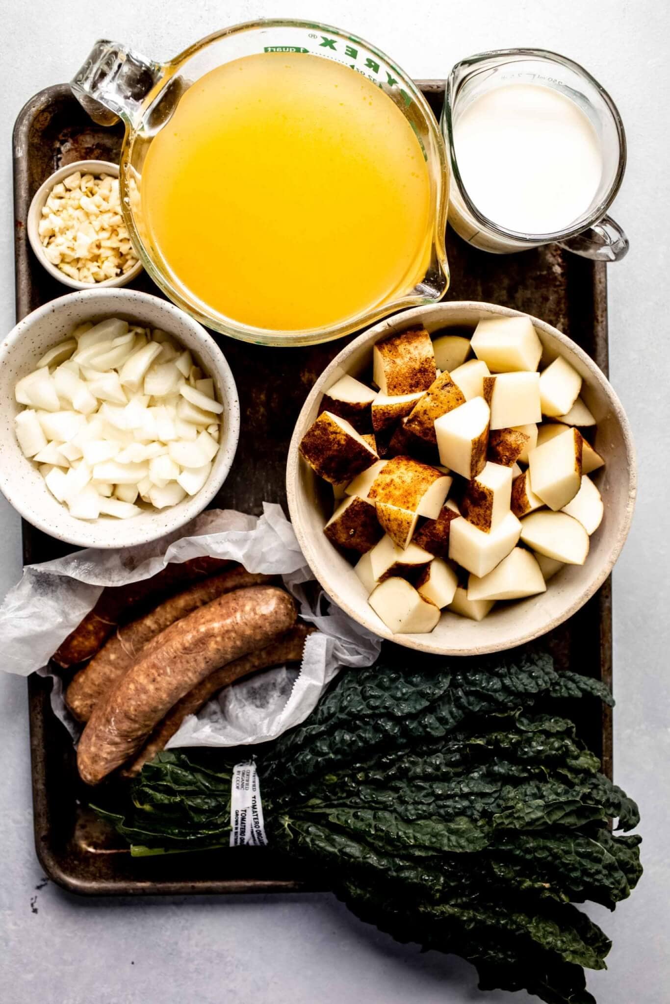 Ingredients for zuppa toscana on baking sheet.