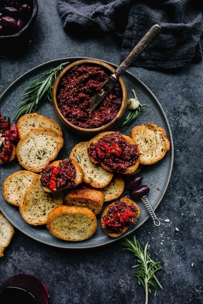 Crostini topped with tapenade and sun dried tomatoes. 