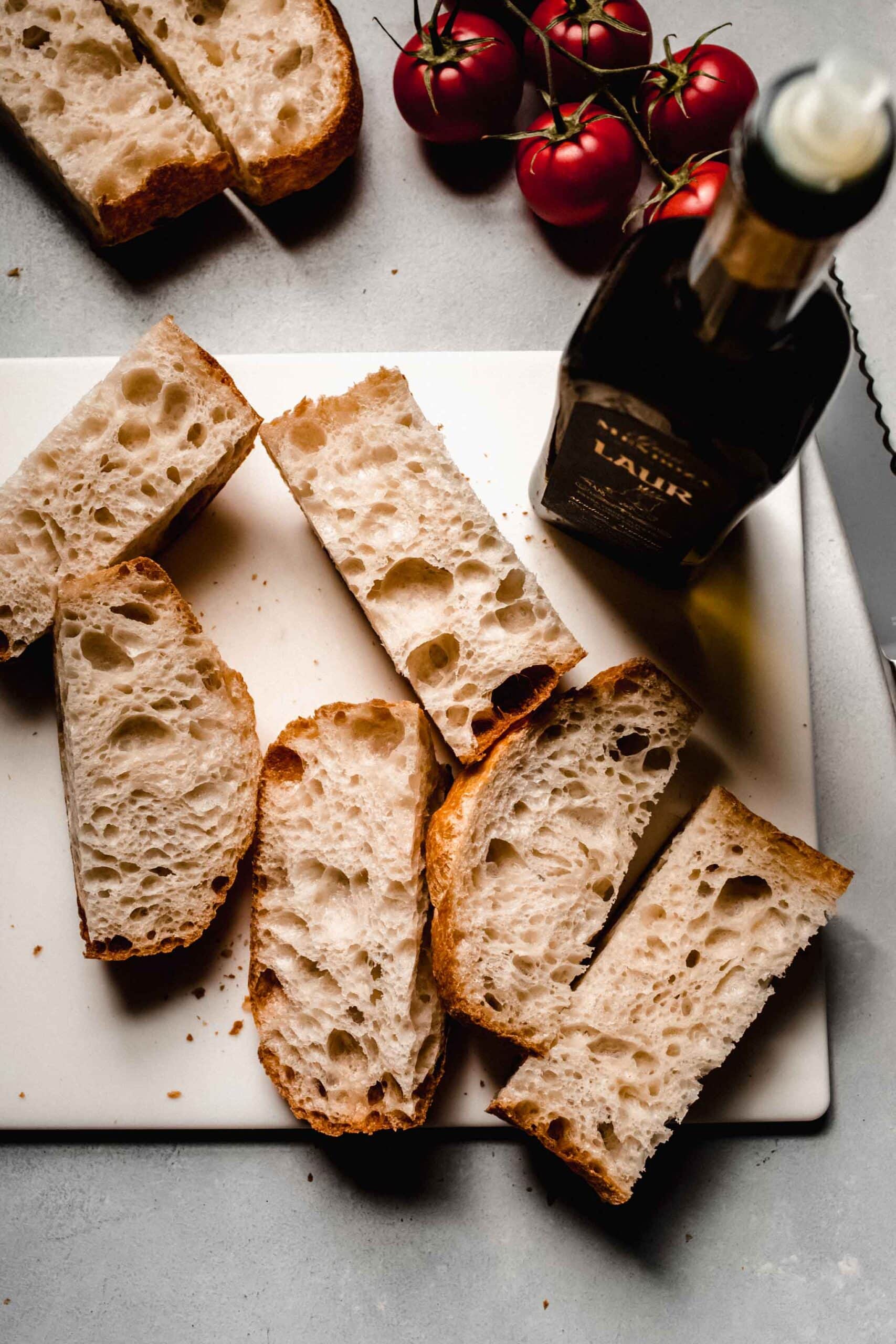 Sliced bread on counter next to olive oil container. 