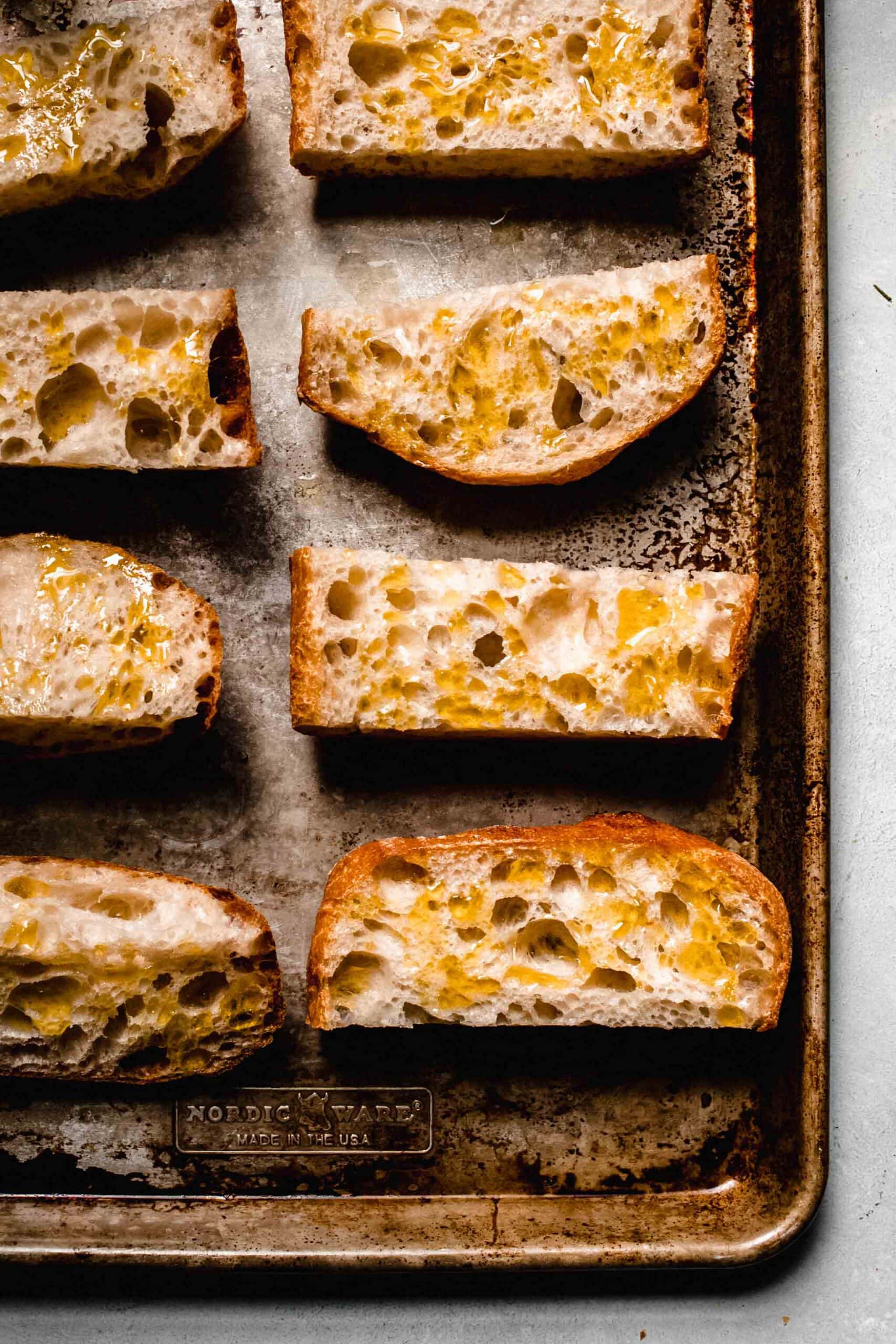 Toasted bread on baking sheet. 