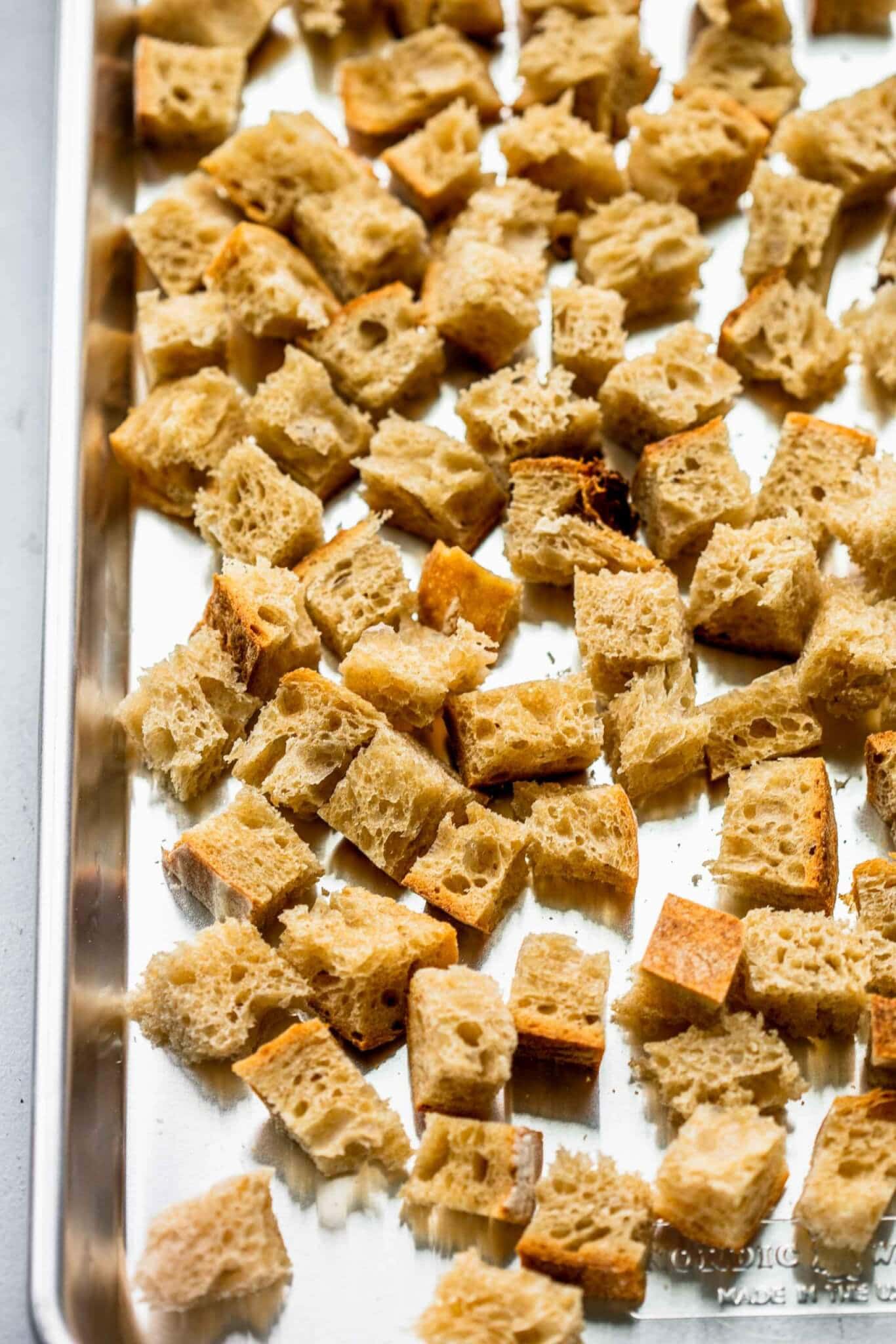 Cubes of bread on baking sheet before going in oven.