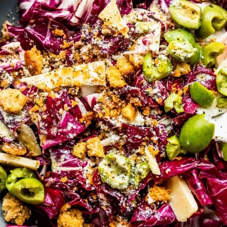 Prepared radicchio salad in grey bowl with serving utensils.