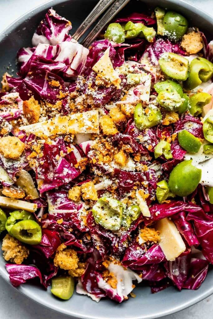 Prepared radicchio salad in grey bowl with serving utensils.